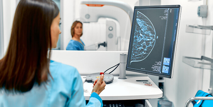 radiologue étidiant les clichés d'une mammographie sur écran