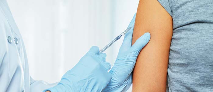 bras de femme en train de se faire vacciner