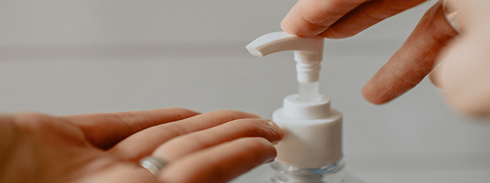gros plan sur des mains appliquant du gel hydroalcoolique