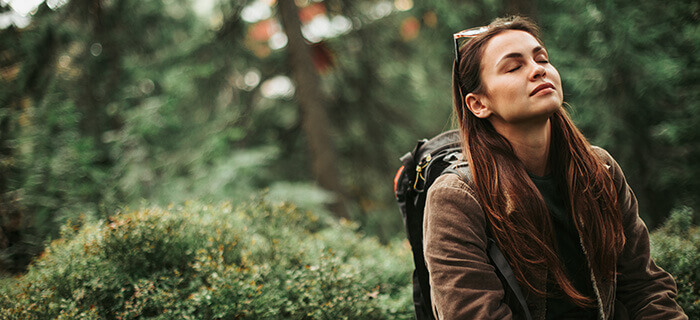 femme méditant tout en se promenant en forêt
