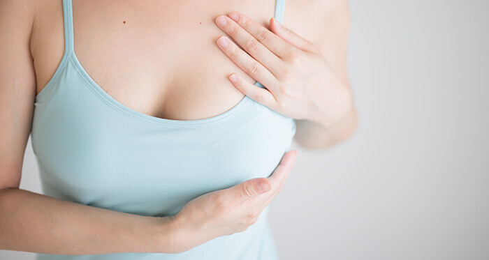 femme se tenant le sein