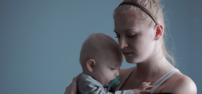 jeune maman maussade avec son bébé dans les bras