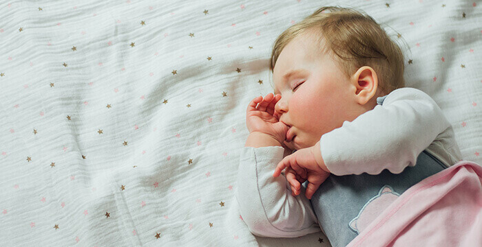 bébé dormant en suçant son pouce