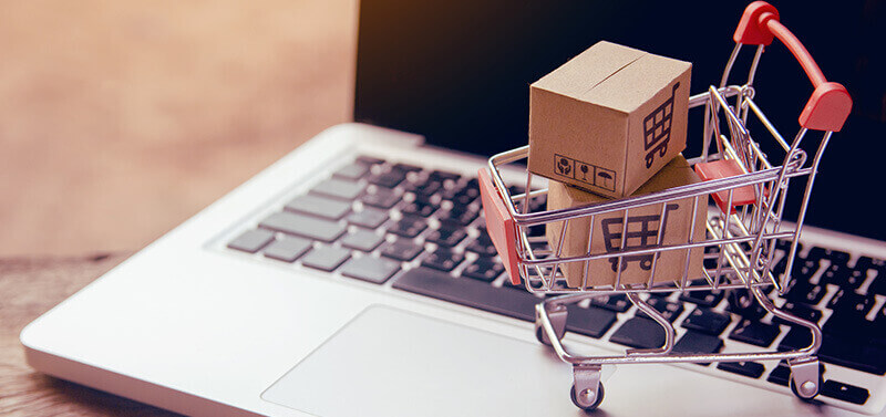 caddie miniature rempli de petits cartons posé sur un ordinateur portable