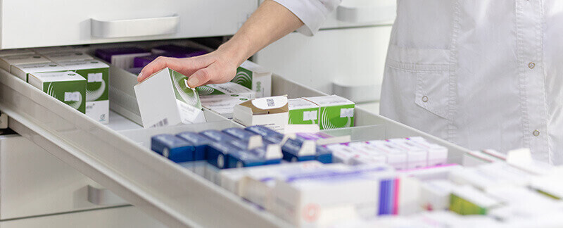 pharmacien prenant un médicament dans un tiroir de pharmacie