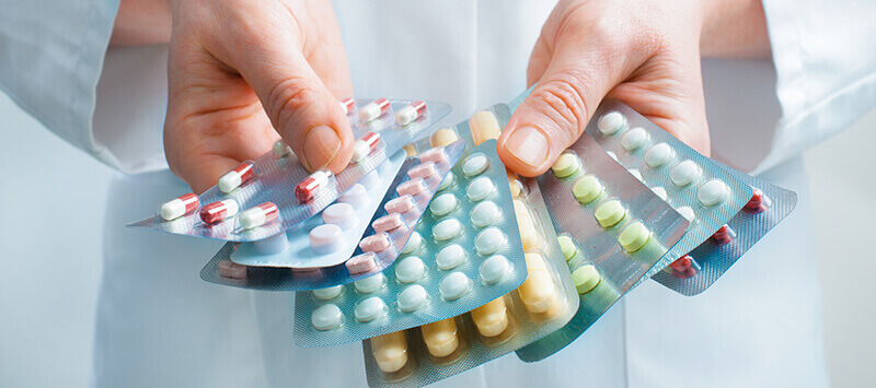 plaquettes de médicaments tenues par un pharmacien